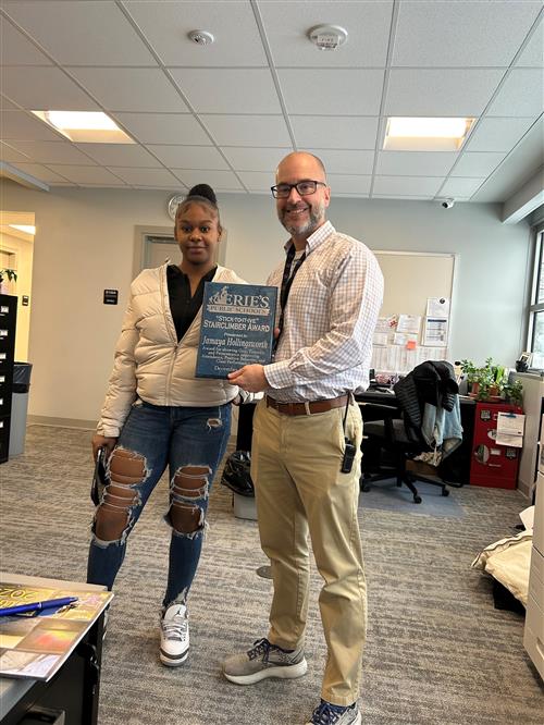 Jamaya Hollingsworth, Erie High's December Stairclimber, poses with her plaque and Principal Orlando.